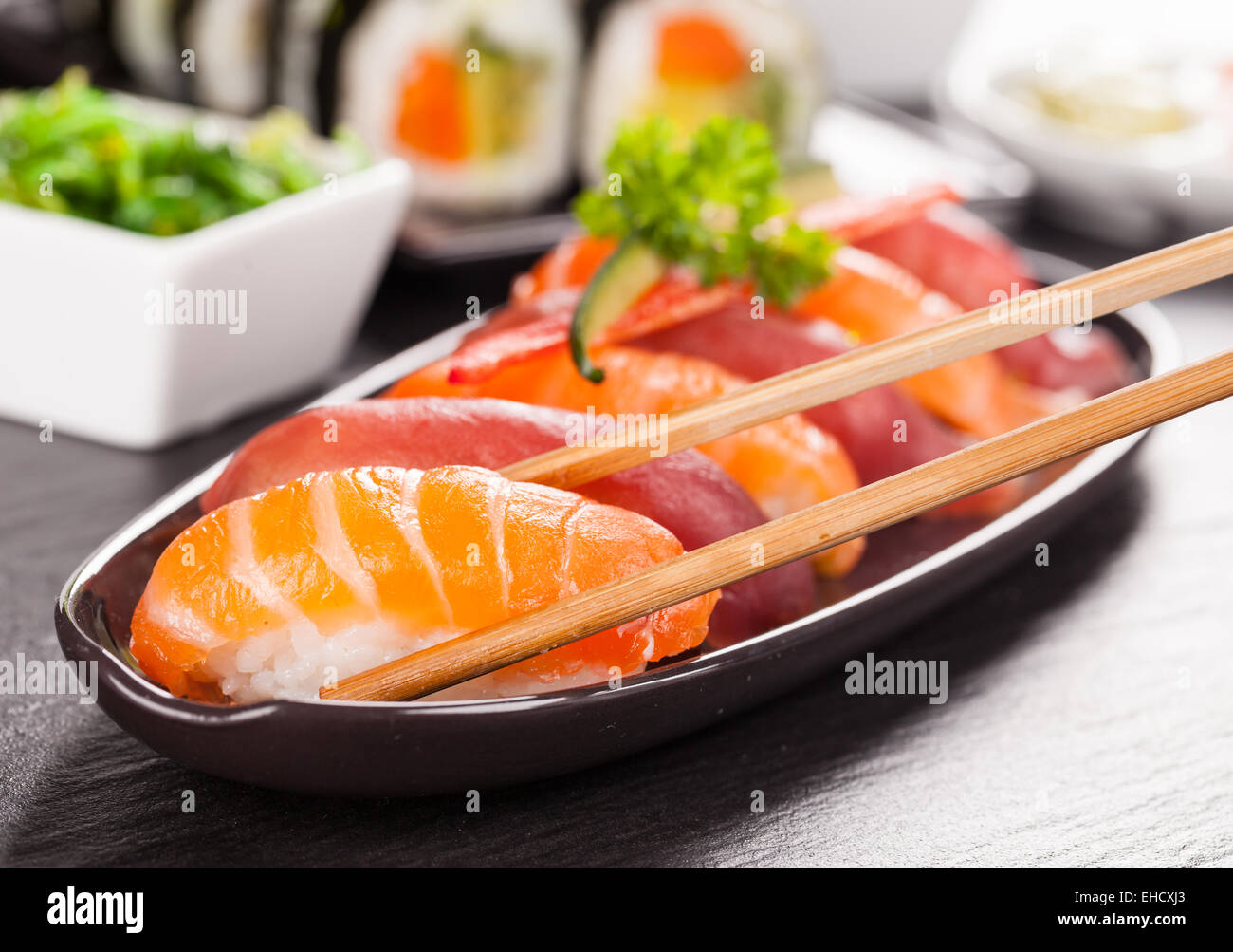 Auf schwarzen Teller und Stein serviert köstliche Sushi-Rollen Stockfoto