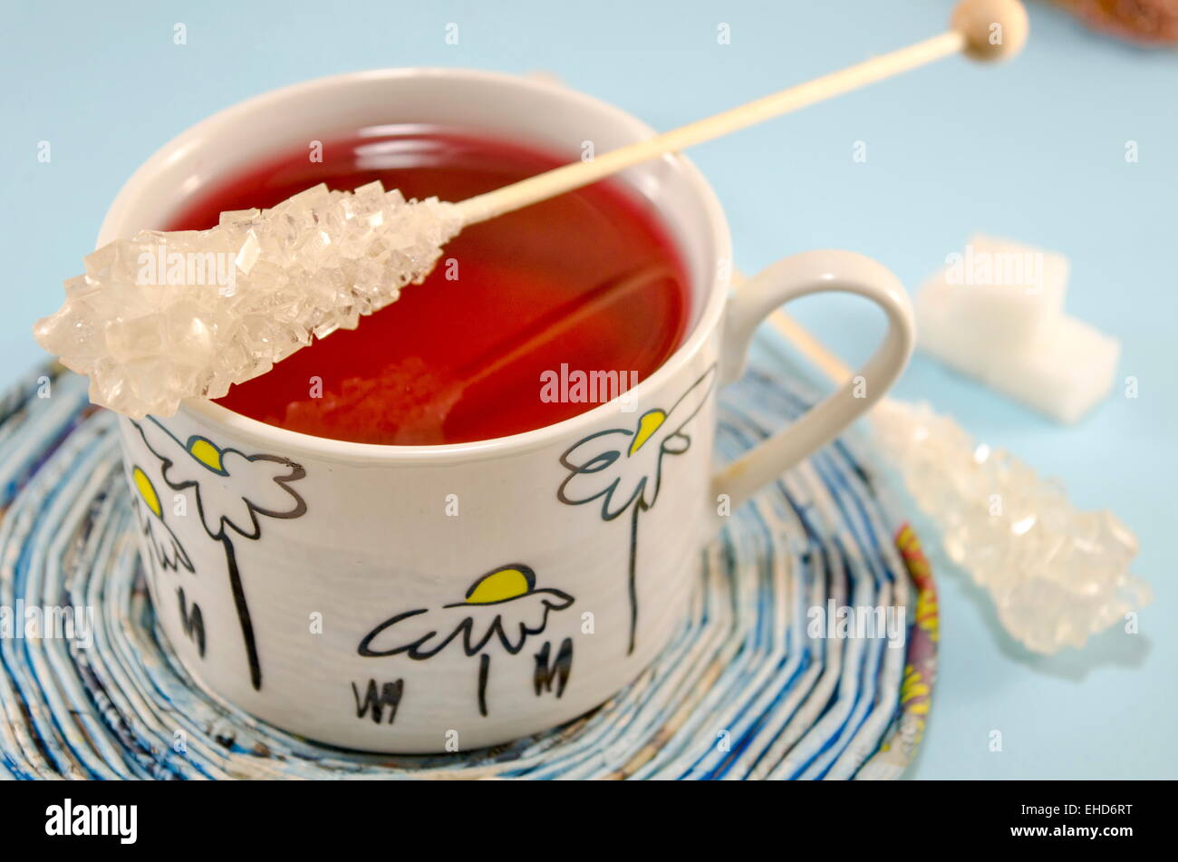 Zucker-Stick auf eine Tasse Tee-Set auf einer blauen Tischdecke Stockfoto