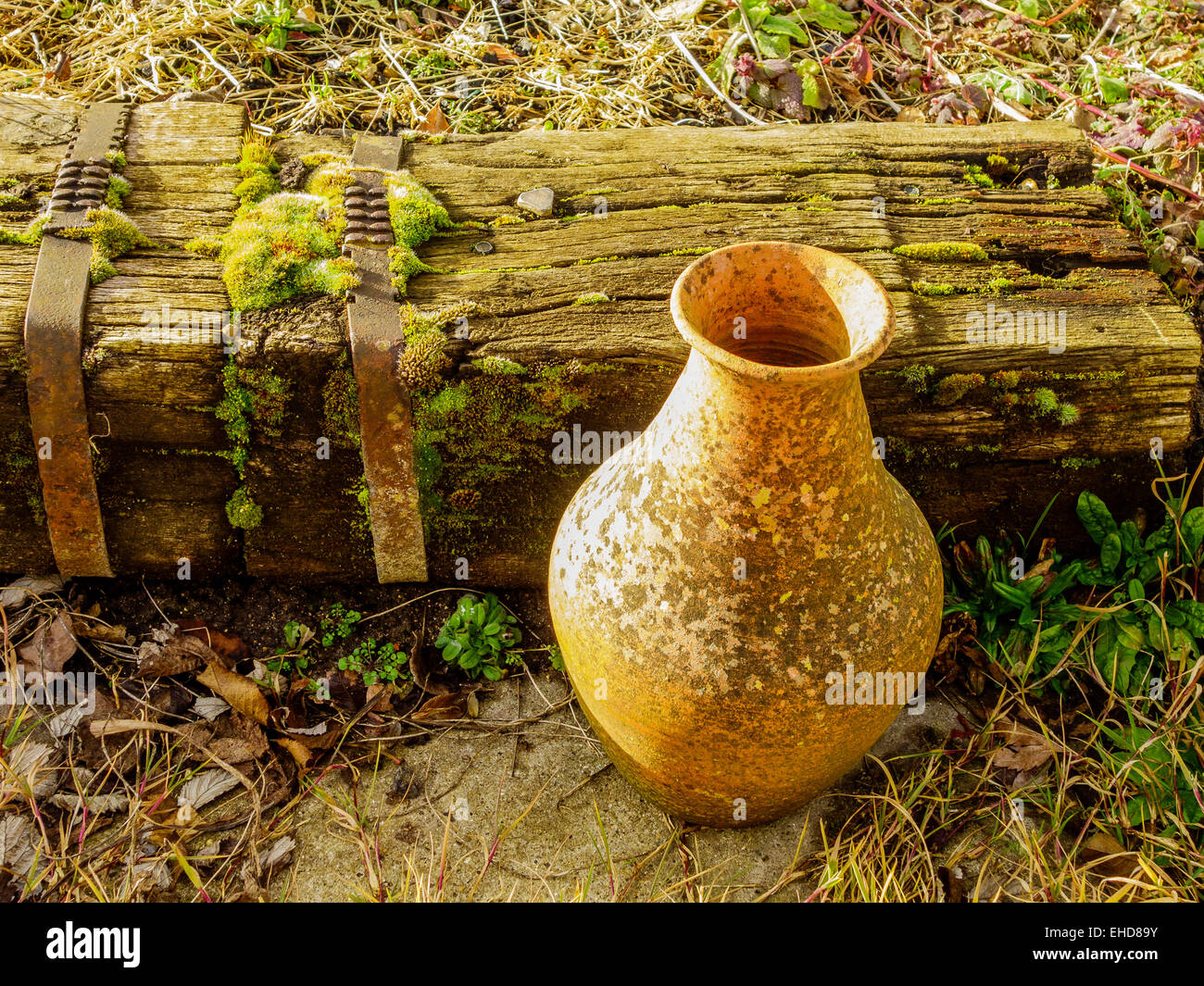 Alten Moos bedeckt Terracotta Topf verfallenden Holzeisenbahn Schläfer Stockfoto