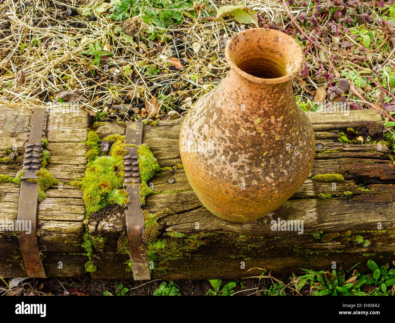 Alten Moos bedeckt Terracotta Topf verfallenden Holzeisenbahn Schläfer Stockfoto