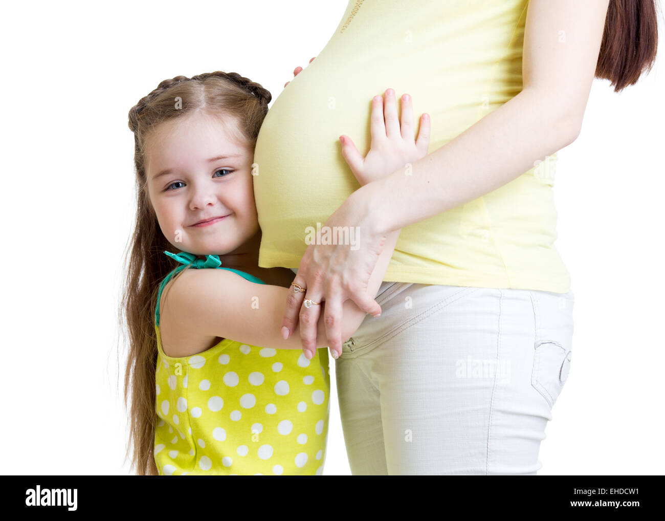 Nettes Kind Mädchen umarmen schwangere Mutter Stockfoto