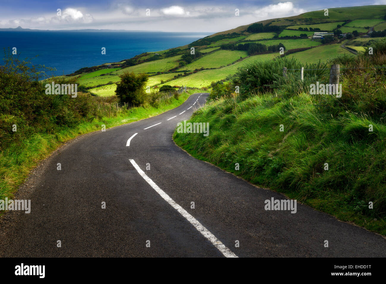 Straße in der Nähe von Torr Head mit grünen Wiesen im Hintergrund. Küste von Antrim-Nordirland Stockfoto