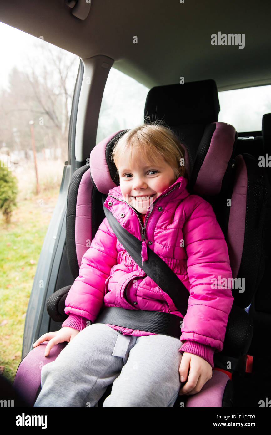 kleines Mädchen in eine rosa Jacke sitzen in einem Autositz Stockfoto