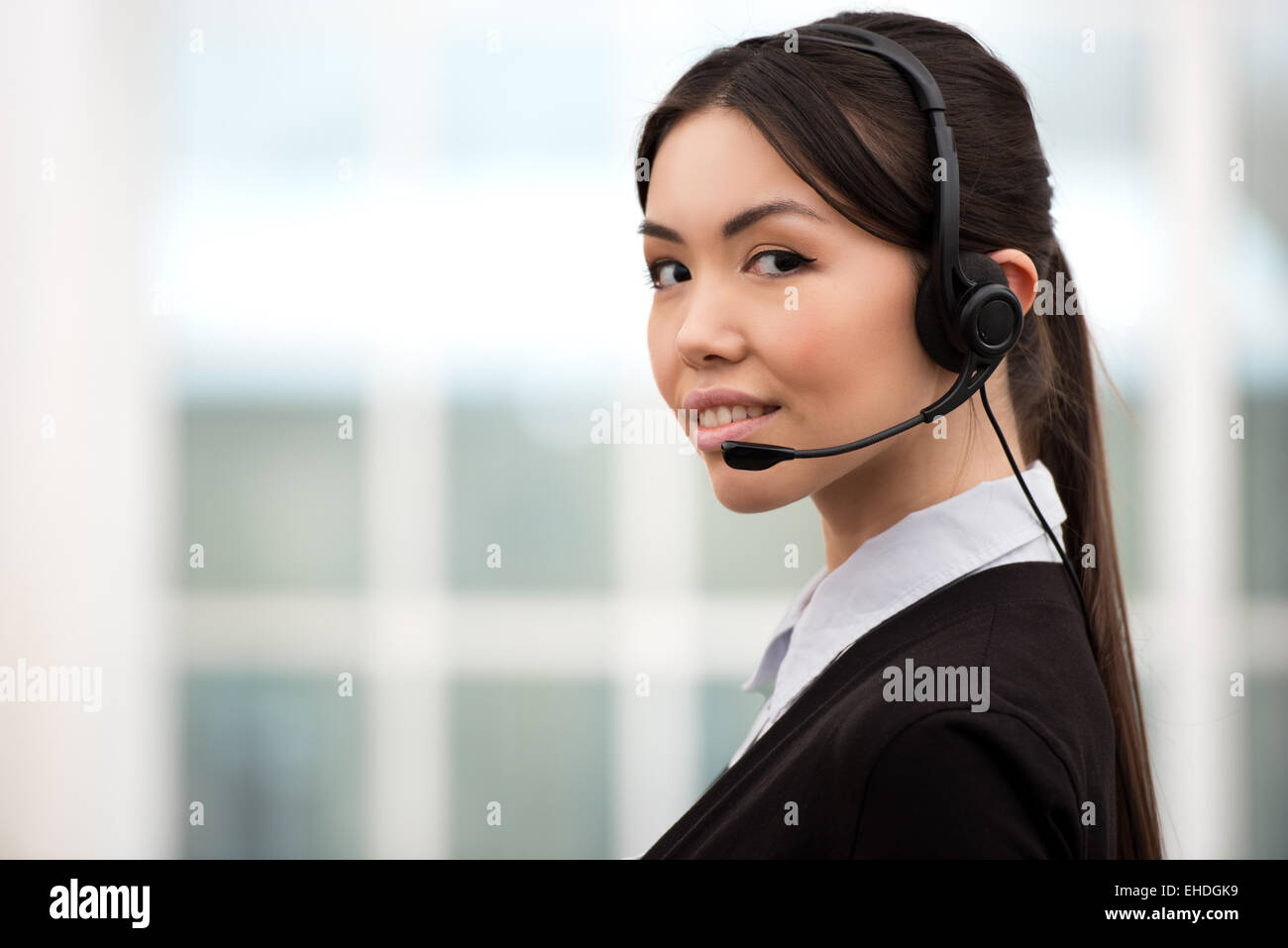Weibliche asiatische Anruf-Center-Betreiber mit Kopfhörer Stockfoto