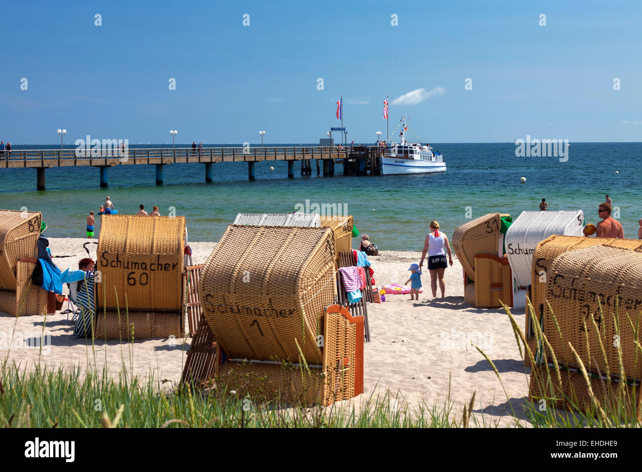 Pier und Sonnenanbeter in Liegestühlen im Badeort Haffkrug, Schleswig-Holstein, Deutschland Stockfoto