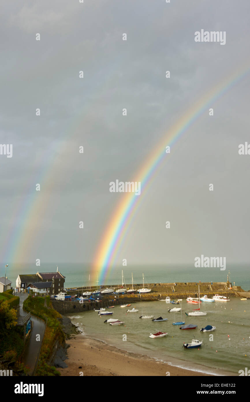 Wales Newquay Hafen.  Boote vertäut im Tierheim. Doppelter Regenbogen über den Wellenbrecher Stockfoto