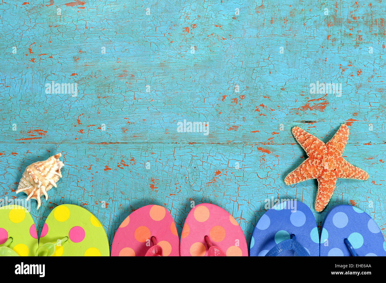 Sommer-Konzept mit Flip Flops in verschiedenen Farben, Seestern und Muschel über Grunge Tisch Stockfoto