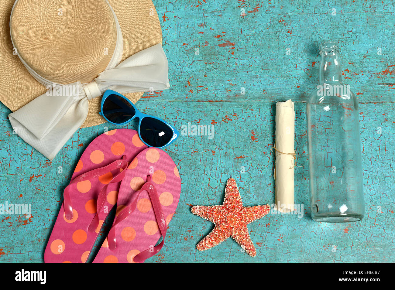 Vintage Tisch mit Sommer-Gegenständen wie Hut, Sonnenbrille, Flip-flops, Seesterne und eine Flaschenpost Stockfoto