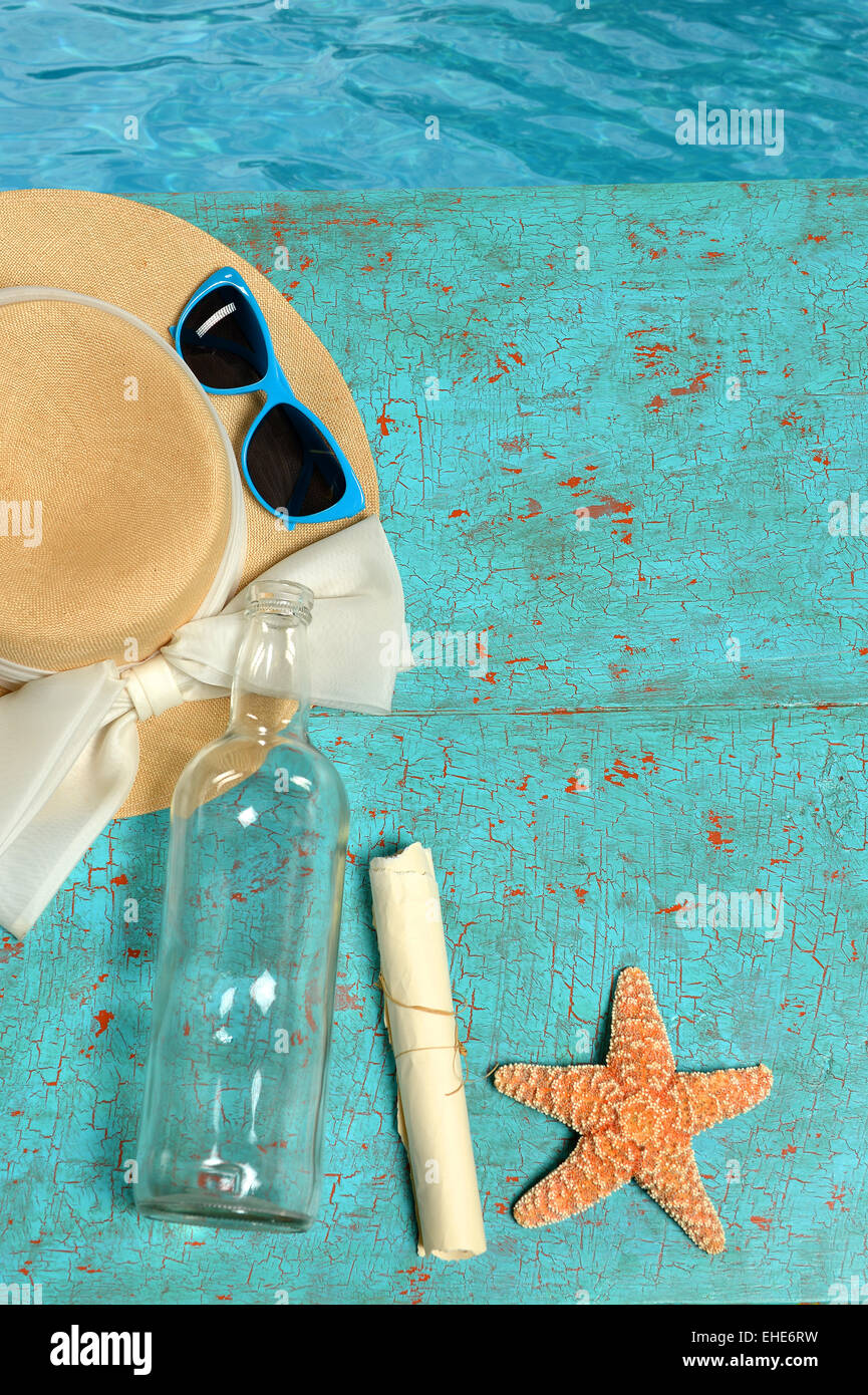 Sommer-Konzept mit Hut, Nachricht in einer Flasche und Seestern auf Grunge-deck Stockfoto
