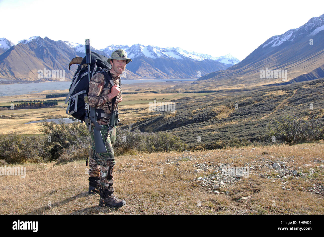 Ein erfolgreicher Jäger ruht mit einer Trophäe Himalaya-Tahr (Hemitragus Jemlahicus) in seinem Rucksack Stockfoto