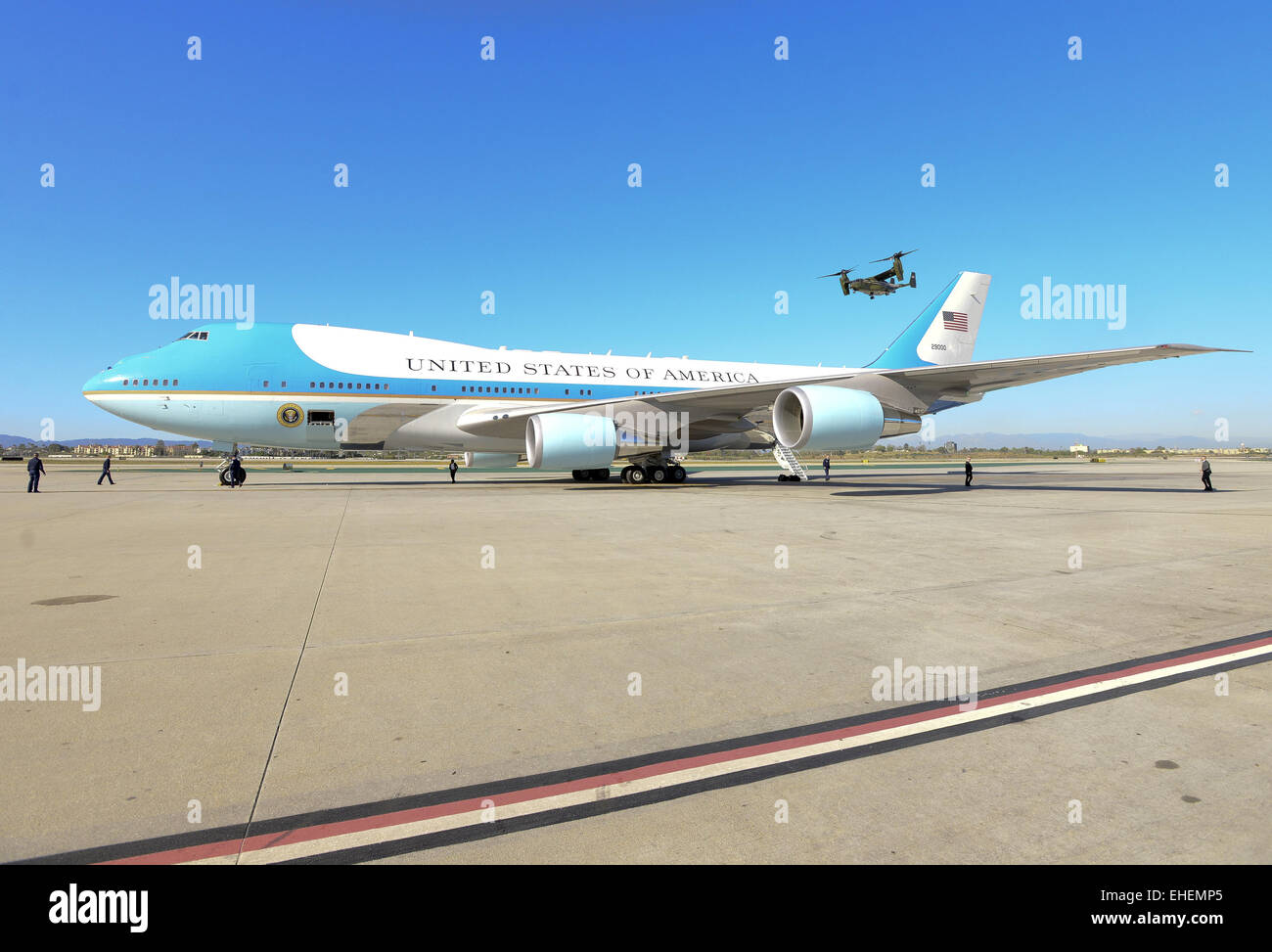 Los Angeles, Kalifornien, USA. 12. März 2015. In ein Dienstprogramm Unterstützungsrolle mit Präsident Obama 12. März 2015 Ankunft am internationalen Flughafen Los Angeles begleitet mehrere MV-22 Osprey, hergestellt von Boeing, vom Marine Corps HMX-1 Hubschrauberstaffel Marine One. Der Fischadler, ein Tilt Rotor Flugzeug, hat die Fähigkeit, fungieren als ein Hubschrauber sowie die ähnlich wie eine traditionelle Prop Flugzeug durchführen. Das Marine Corps HMX-1squadron diente als Präsidenten und VIP transport seit 1947.---ein Fischadler kann gesehen werden, da es entlang der Flightline hinter einem geparkten Air Force One Am hebt ab Stockfoto