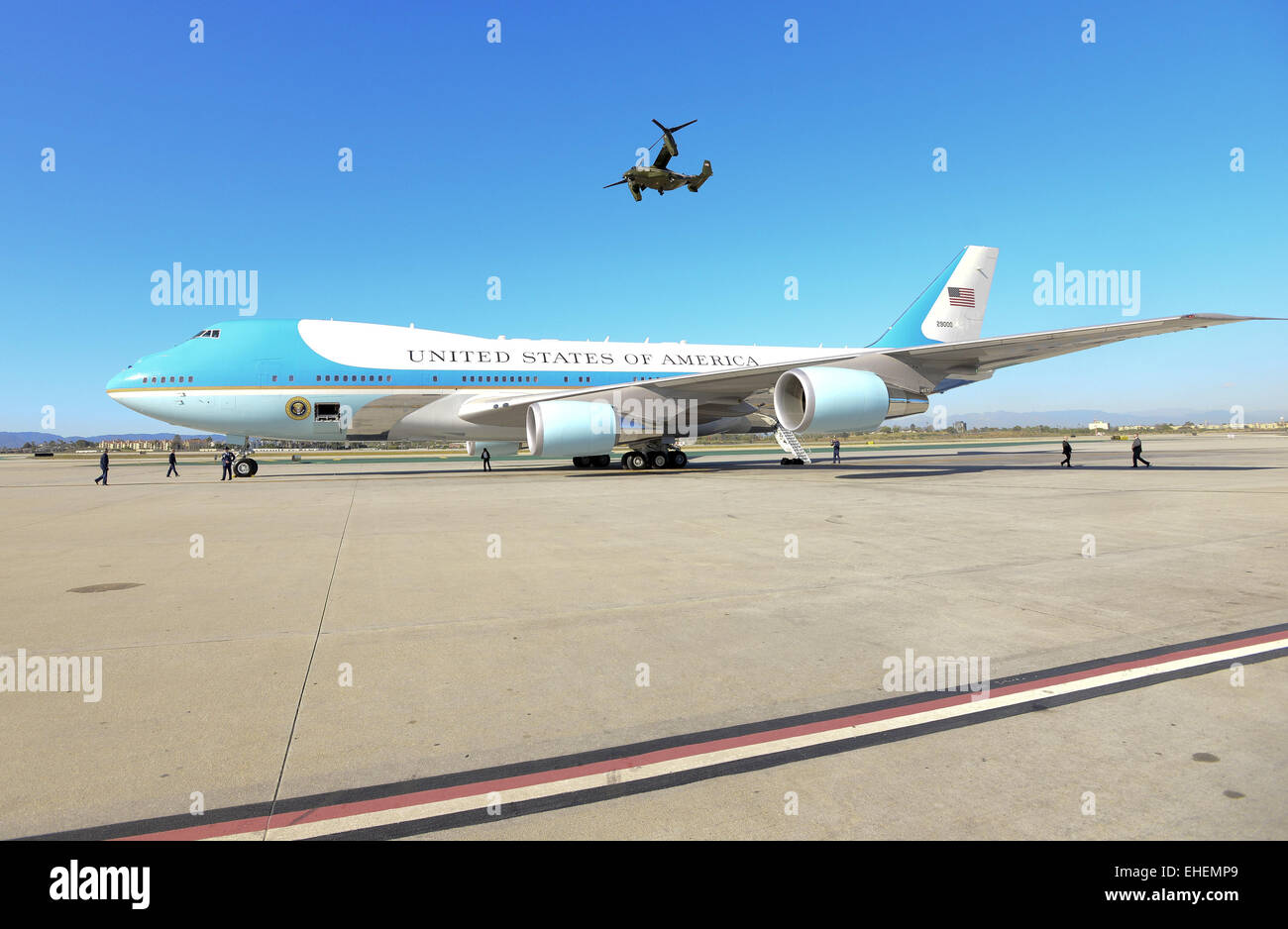 Los Angeles, Kalifornien, USA. 12. März 2015. In ein Dienstprogramm Unterstützungsrolle mit Präsident Obama 12. März 2015 Ankunft am internationalen Flughafen Los Angeles begleitet mehrere MV-22 Osprey, hergestellt von Boeing, vom Marine Corps HMX-1 Hubschrauberstaffel Marine One. Der Fischadler, ein Tilt Rotor Flugzeug, hat die Fähigkeit, fungieren als ein Hubschrauber sowie die ähnlich wie eine traditionelle Prop Flugzeug durchführen. Das Marine Corps HMX-1squadron diente als Präsidenten und VIP transport seit 1947.---ein Fischadler kann gesehen werden, da es entlang der Flightline hinter einem geparkten Air Force One Am hebt ab Stockfoto