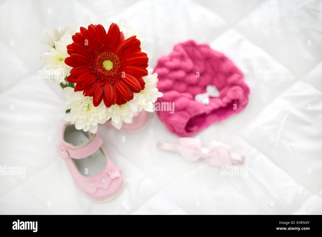 Gerbera-rosa Baby-Schuhe und Kopfbedeckung rosa in natürlichem Licht Stockfoto