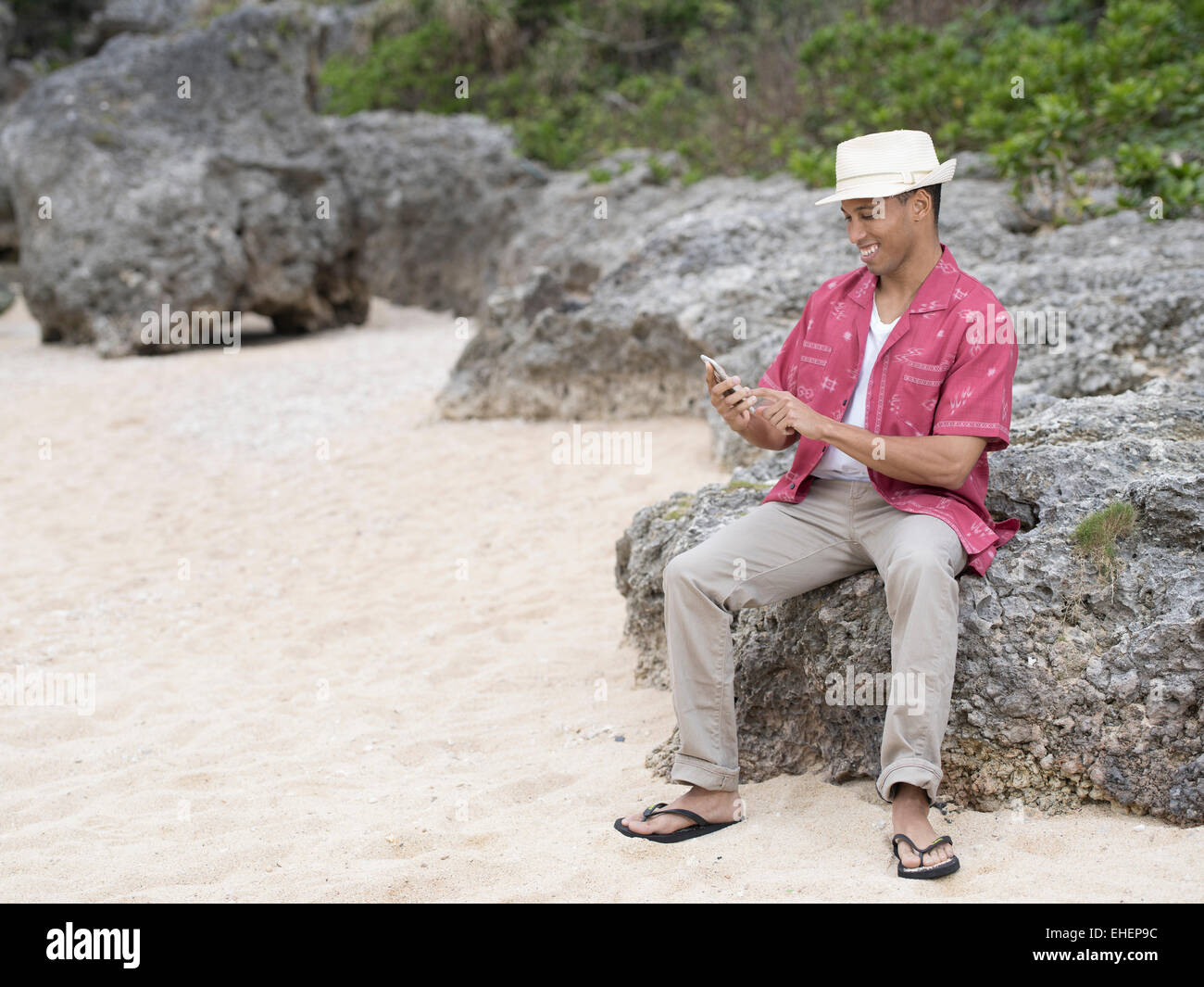 Mann SMS / Überprüfung Internet auf Apple Iphone 6 Smartphone am Strand Stockfoto