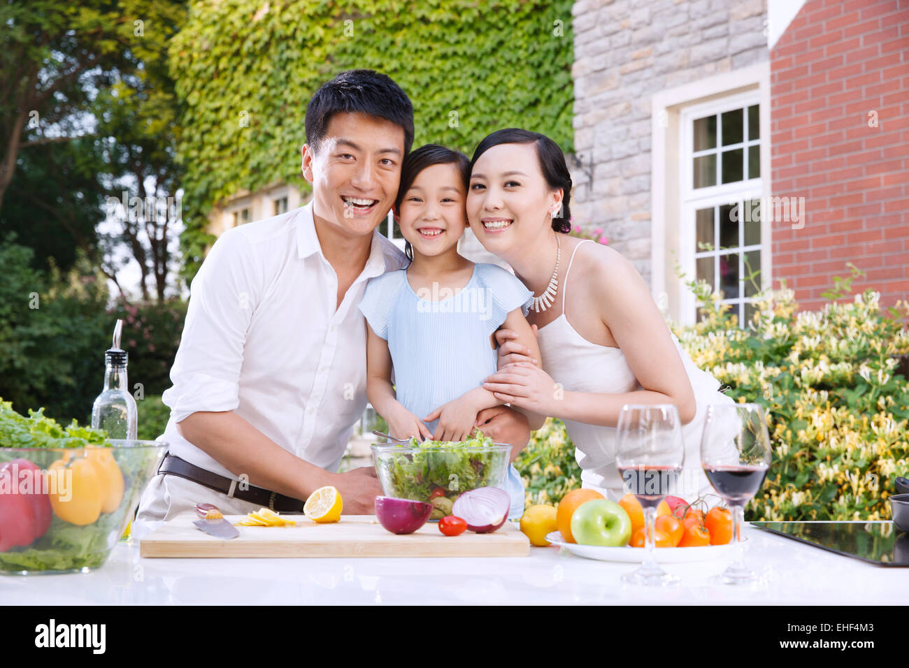 Eine Familie mit drei Wange an Wange in die Outdoor-Küche Stockfoto