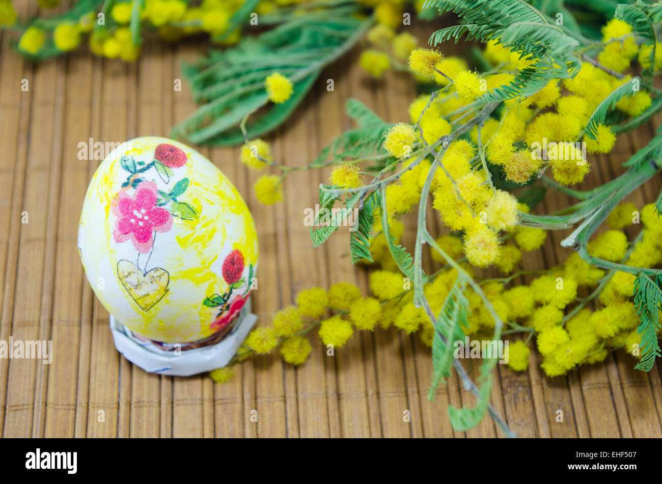 Handgemalte Decoupage Osterei und Mimosen Blüten Stockfoto