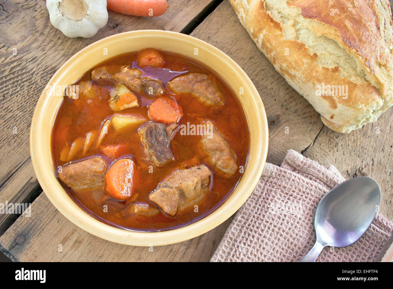 Schweinefleisch-Eintopf in Keramikschale auf hölzernen Hintergrund Stockfoto