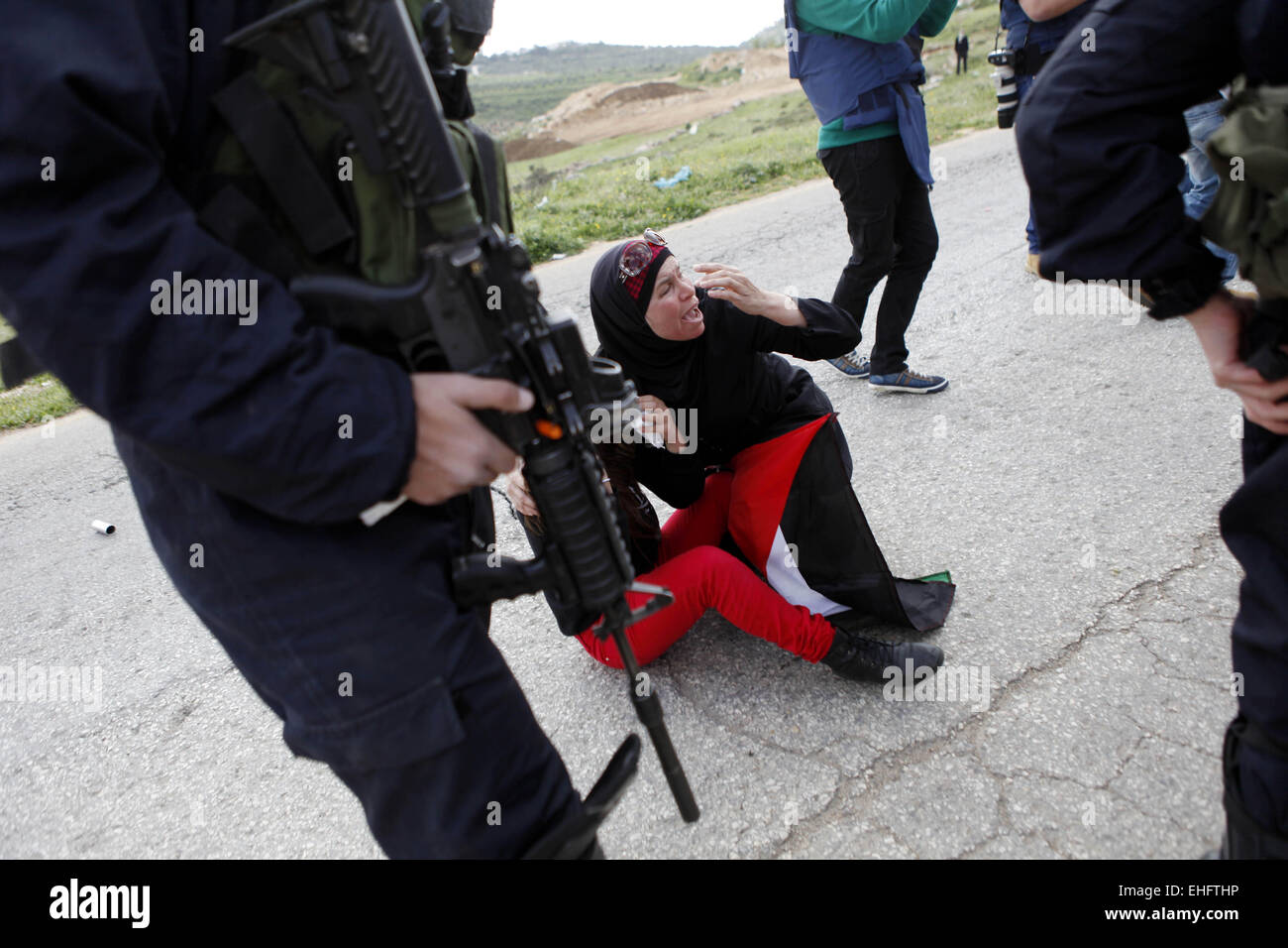 Nabi Saleh, West Bank. 13. März 2015. Eine Palästinenserin Raufereien mit israelischen Soldaten während der Auseinandersetzungen nach einer Demonstration gegen den Ausbau der jüdischen Siedlungen auf palästinensischem Land, in das Westjordanland Dorf von Nabi Saleh, in der Nähe von Ramallah. © Shadi Hatem/APA-Images/ZUMA Draht/Alamy Live News Stockfoto