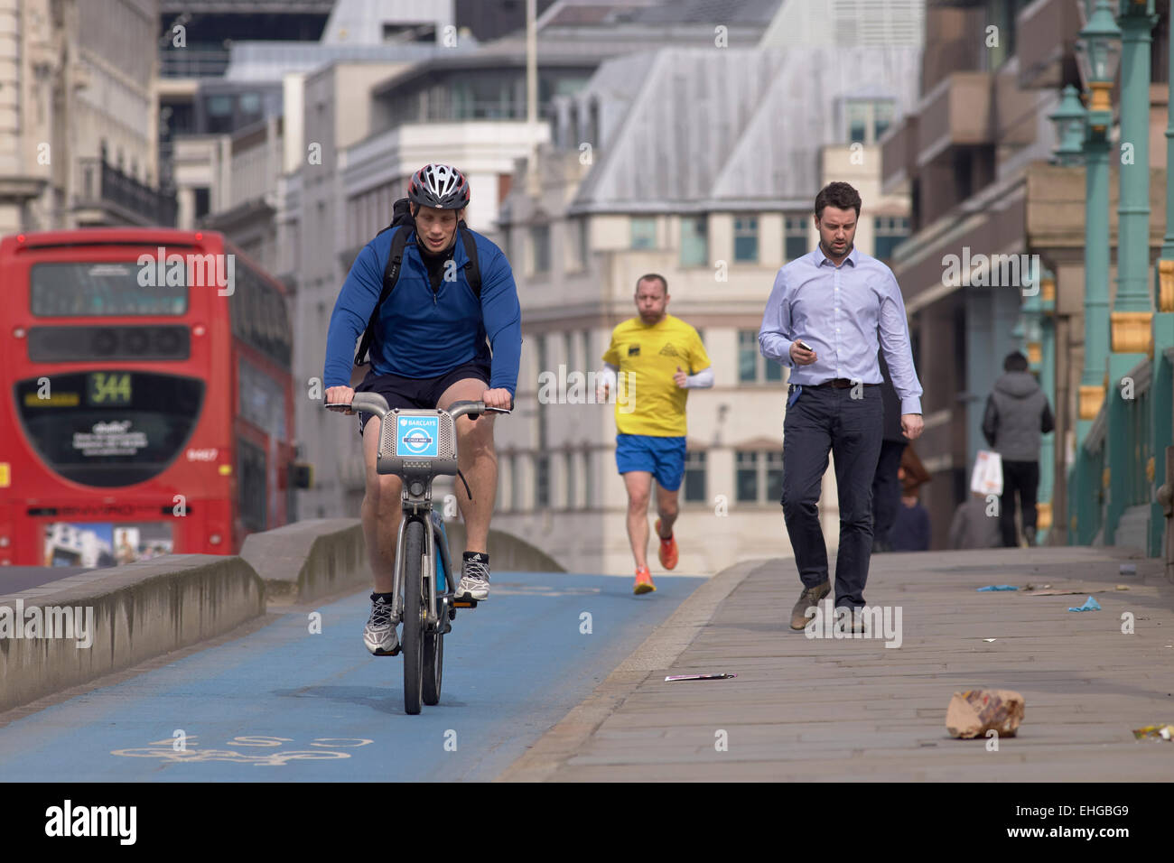 Radfahrer und Jogger auf die Zyklus-Autobahn überqueren Southwark Bridge, London, UK. Stockfoto