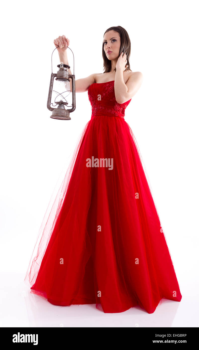 Schöne Frau in einem roten Kleid hält eine Gaslampe Stockfoto
