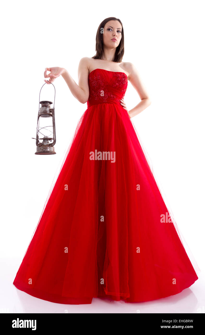 Schöne Frau in einem roten Kleid hält eine Gaslampe Stockfoto