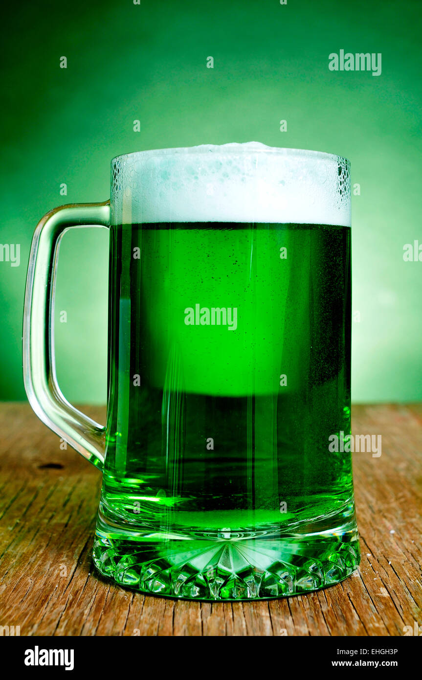 ein Glaskrug mit gefärbten Jungbier auf einer rustikalen Holzoberfläche Stockfoto