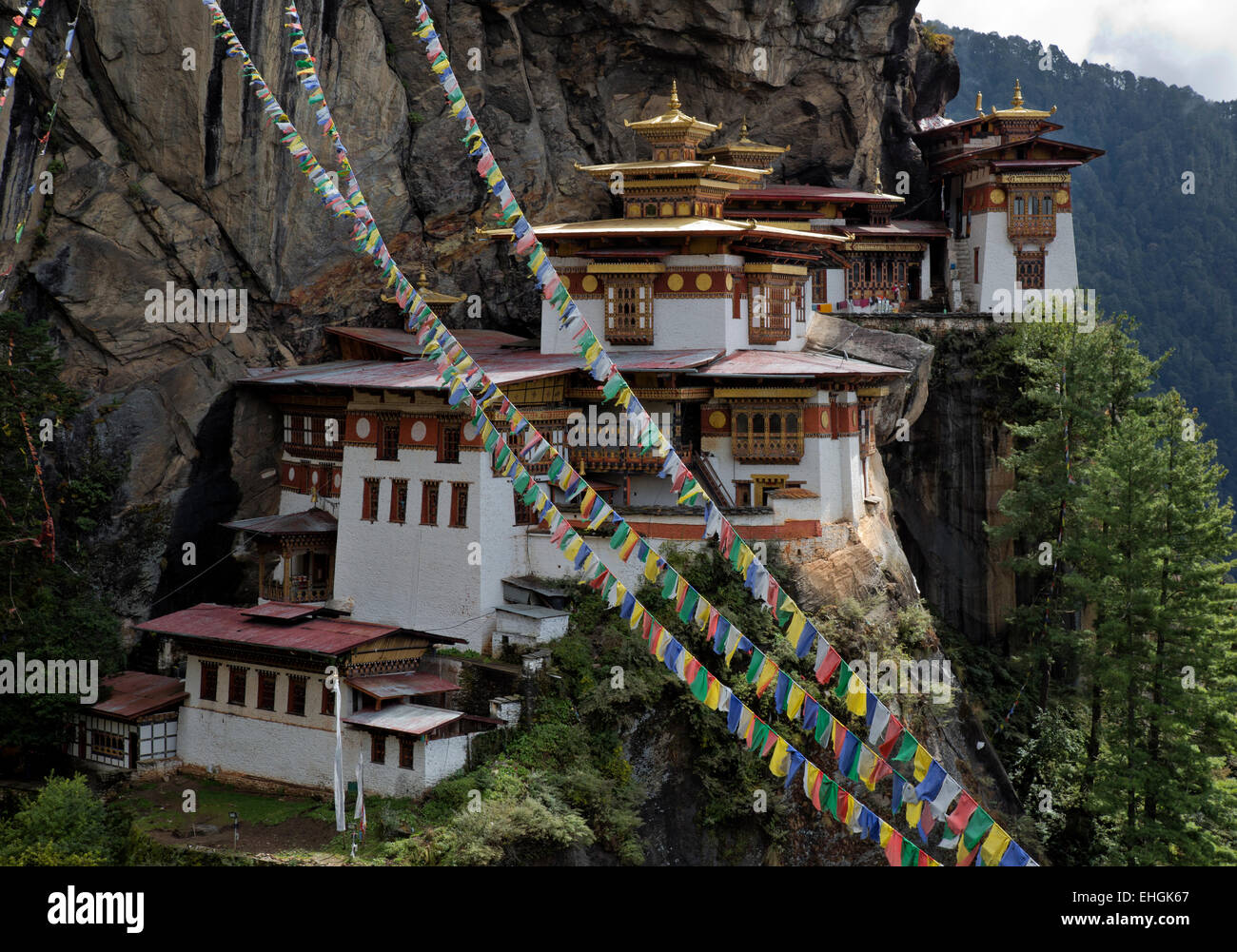 BHUTAN - Gebetsfahnen an Taktshang Goemba, des Tigers Nest Kloster thront auf der Seite einer Klippe hoch über dem Paro Tal. Stockfoto