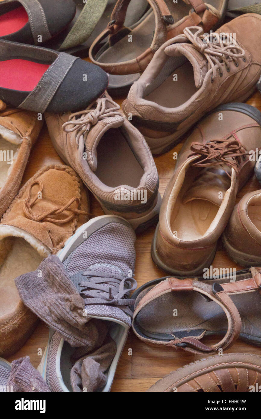 Ein Haufen alter, gut getragen, bequeme Schuhe und Socken alle zusammen auf ein Hartholz Stock Stockfoto