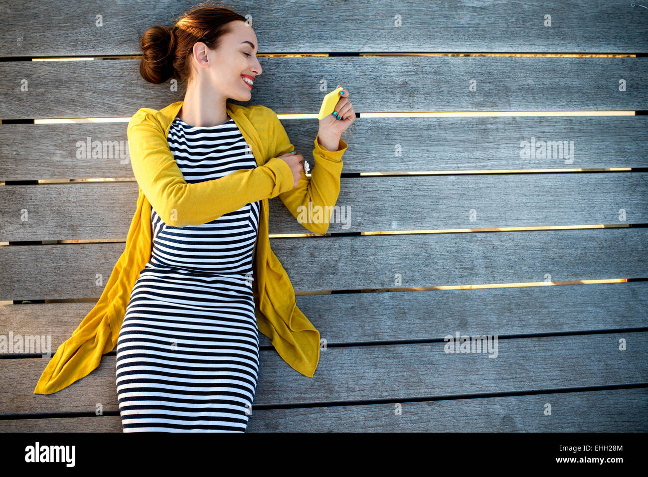 Frau mit Telefon auf Sonnenbank Stockfoto