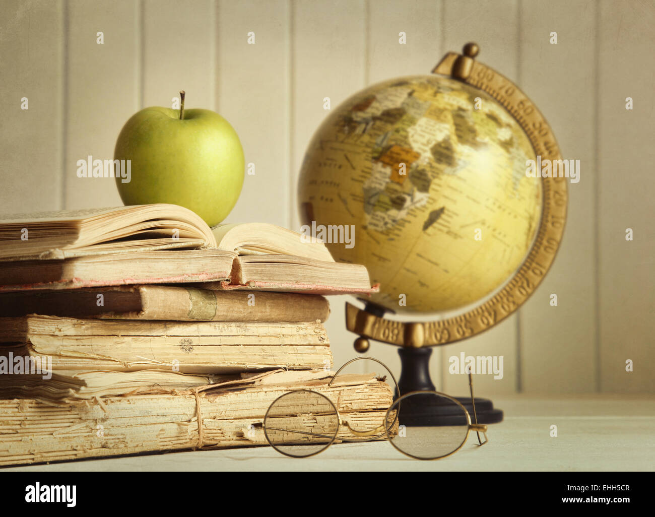 Alte Bücher mit Apfel und Globus Stockfoto