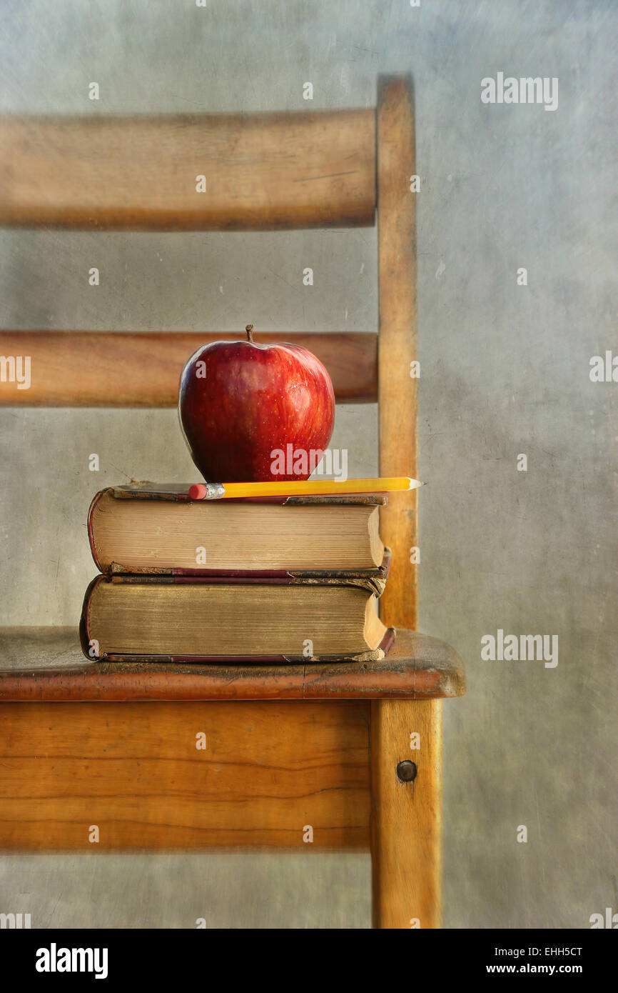 Apple und alte Bücher auf Lehrstühle Stockfoto