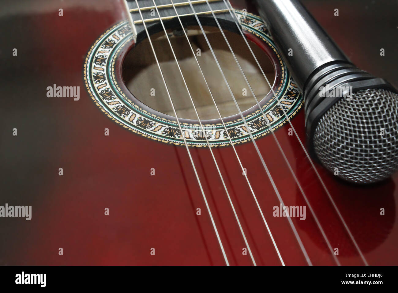 dunkle rote Gitarre und Fragment des Mikrofons Stockfoto dunkle rote Gitarre und Fragment des Mikrofons Stockfoto