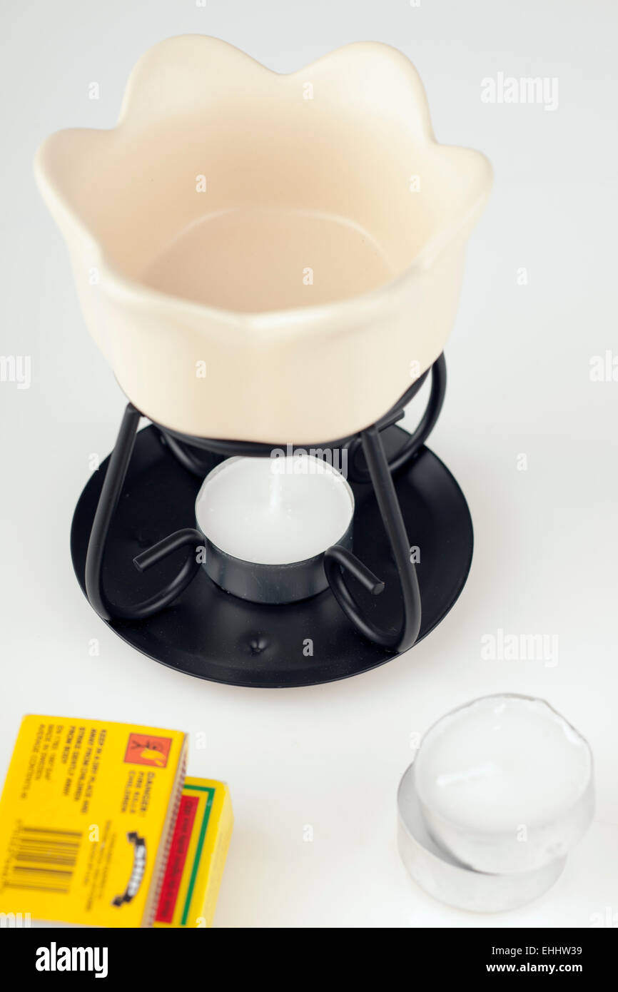 Diffusor aus cremefarbenem Wachsöl, Teelichterkerzen und Streichholzschachteln Stockfoto