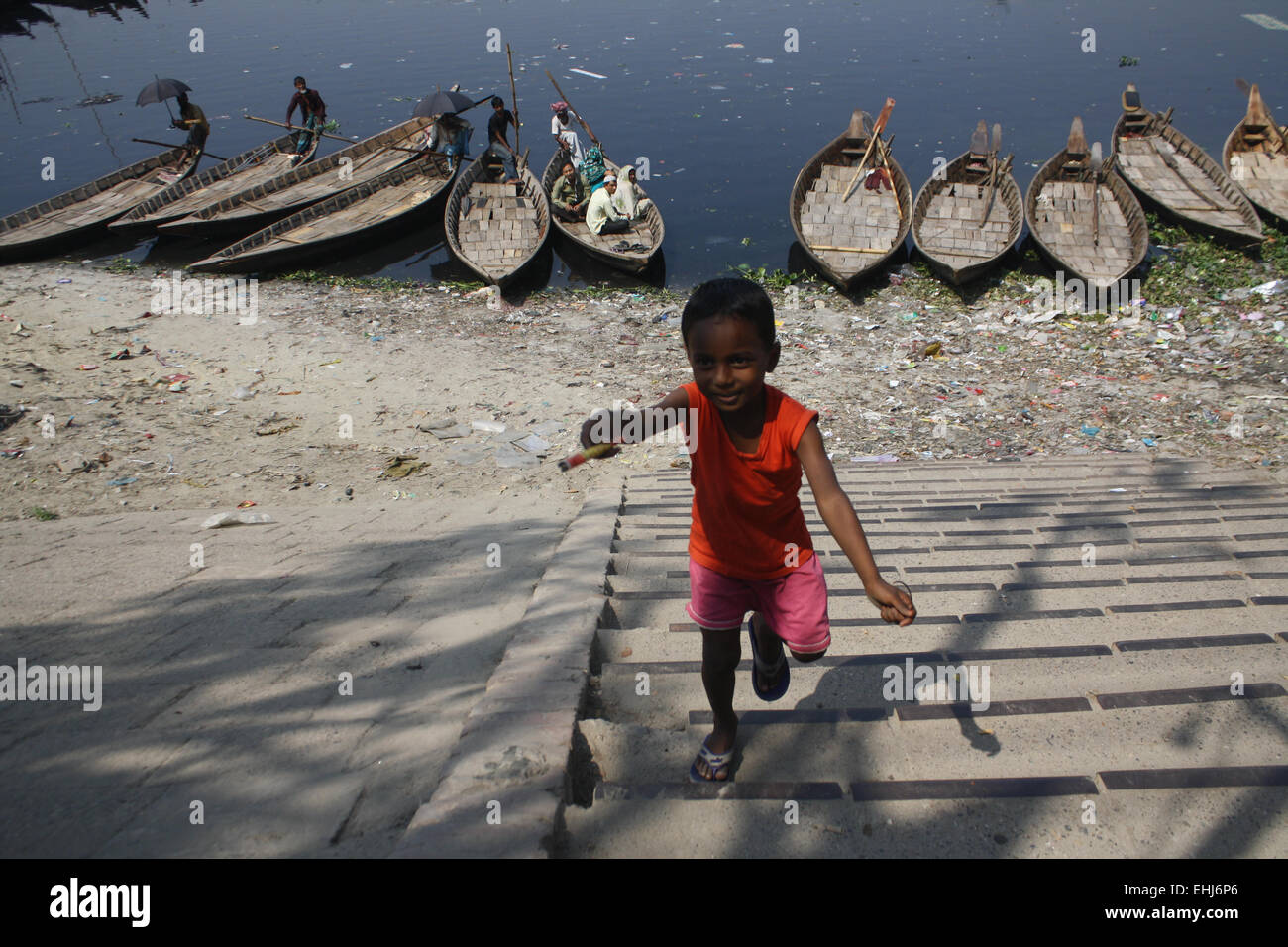 Ein Kind spielt am verschmutztes Buriganga Flussufer in Dhaka, Bangladesch. Verunreinigung des Wassers im Fluss Buriganga hat alarmierende Ausmaße angenommen. Millionen Kubikmeter giftiger Abfälle aus den Tausenden von Industrien und gekrönt mit einer riesigen Menge an unbehandeltem Abwasser aus der Stadt. 14. März ist der International Day of Action für Flüsse und Talsperren. Jedes Jahr heben Tausende von Menschen auf der ganzen Welt ihre Stimmen, um feiern Flüsse der Welt und diejenigen, die kämpfen, um sie zu schützen. International Day of Action für Flüsse ist ein Tag zum feiern Siege wie dam Entfernung und Fluss wieder Stockfoto