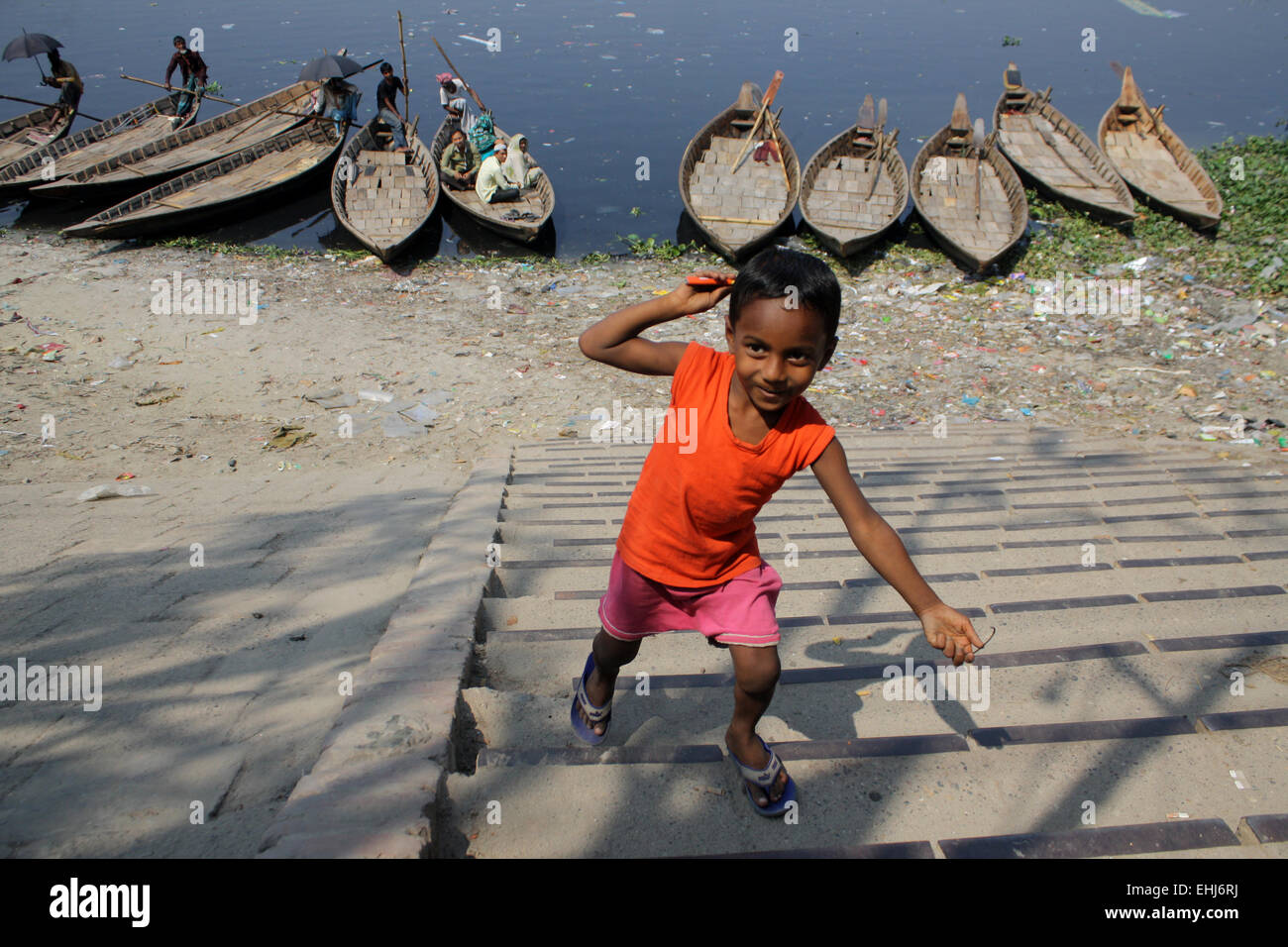 Ein Kind spielt am verschmutztes Buriganga Flussufer in Dhaka, Bangladesch. Verunreinigung des Wassers im Fluss Buriganga hat alarmierende Ausmaße angenommen. Millionen Kubikmeter giftiger Abfälle aus den Tausenden von Industrien und gekrönt mit einer riesigen Menge an unbehandeltem Abwasser aus der Stadt. 14. März ist der International Day of Action für Flüsse und Talsperren. Jedes Jahr heben Tausende von Menschen auf der ganzen Welt ihre Stimmen, um feiern Flüsse der Welt und diejenigen, die kämpfen, um sie zu schützen. International Day of Action für Flüsse ist ein Tag zum feiern Siege wie dam Entfernung und Fluss wieder Stockfoto