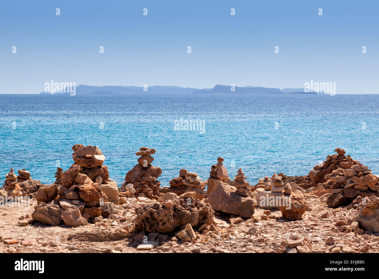 Zen Stein Stapel am Kiesstrand vor einer Insel Stockfoto