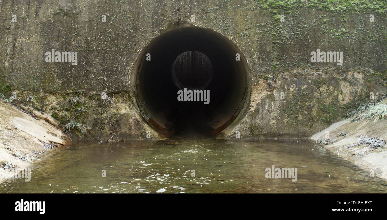 Wasser-Entwässerungsrinne auf schwarzes Loch Stockfoto