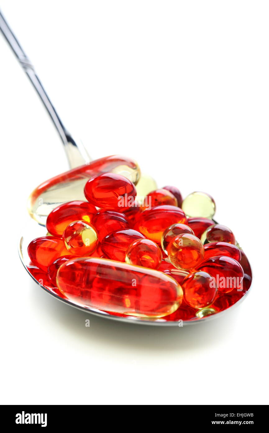 Kapseln mit Vitaminen in einen Löffel. Stockfoto