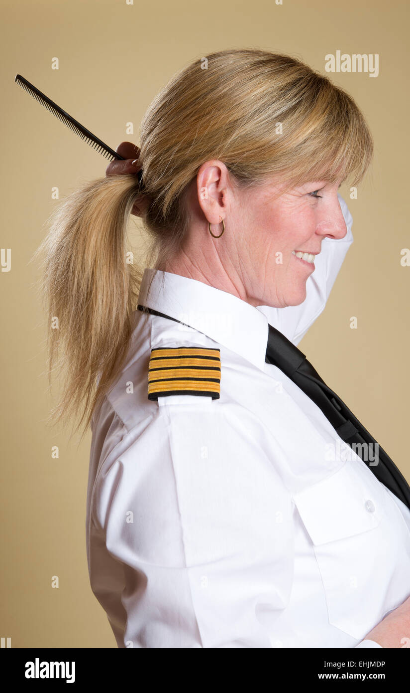Attraktive Airline Pilot Kämmen ihre Haare kämmen Stockfoto