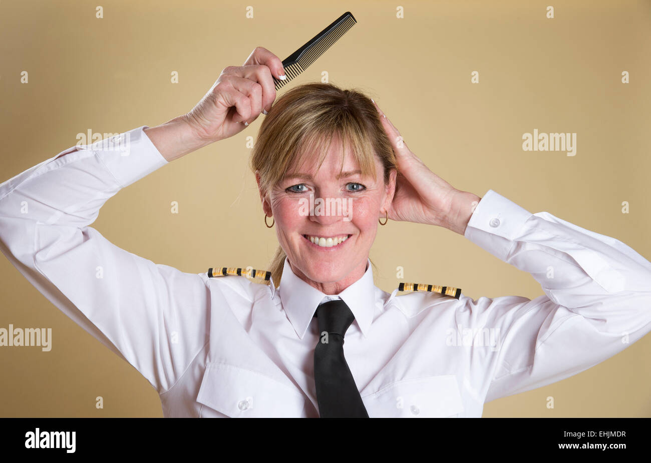 Attraktive Airline Pilot Kämmen ihre Haare kämmen Stockfoto