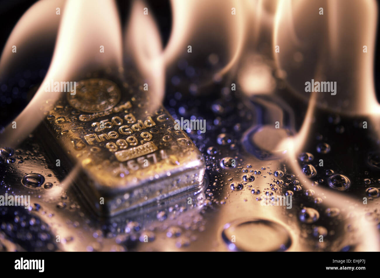Goldbarren und Flamme Stockfoto