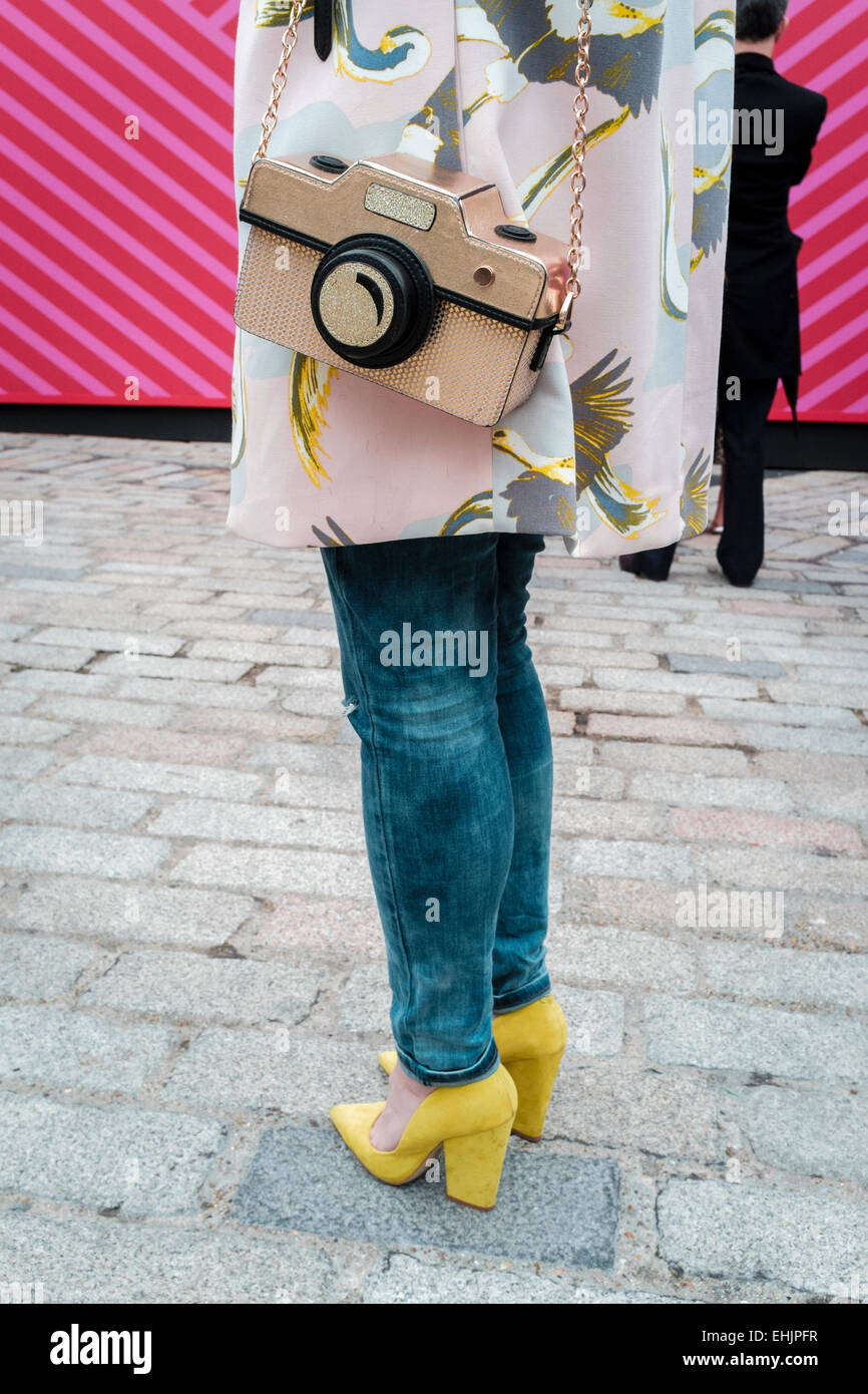 Eine junge Frau, die eine Kamera geformte Handtasche Stockfoto