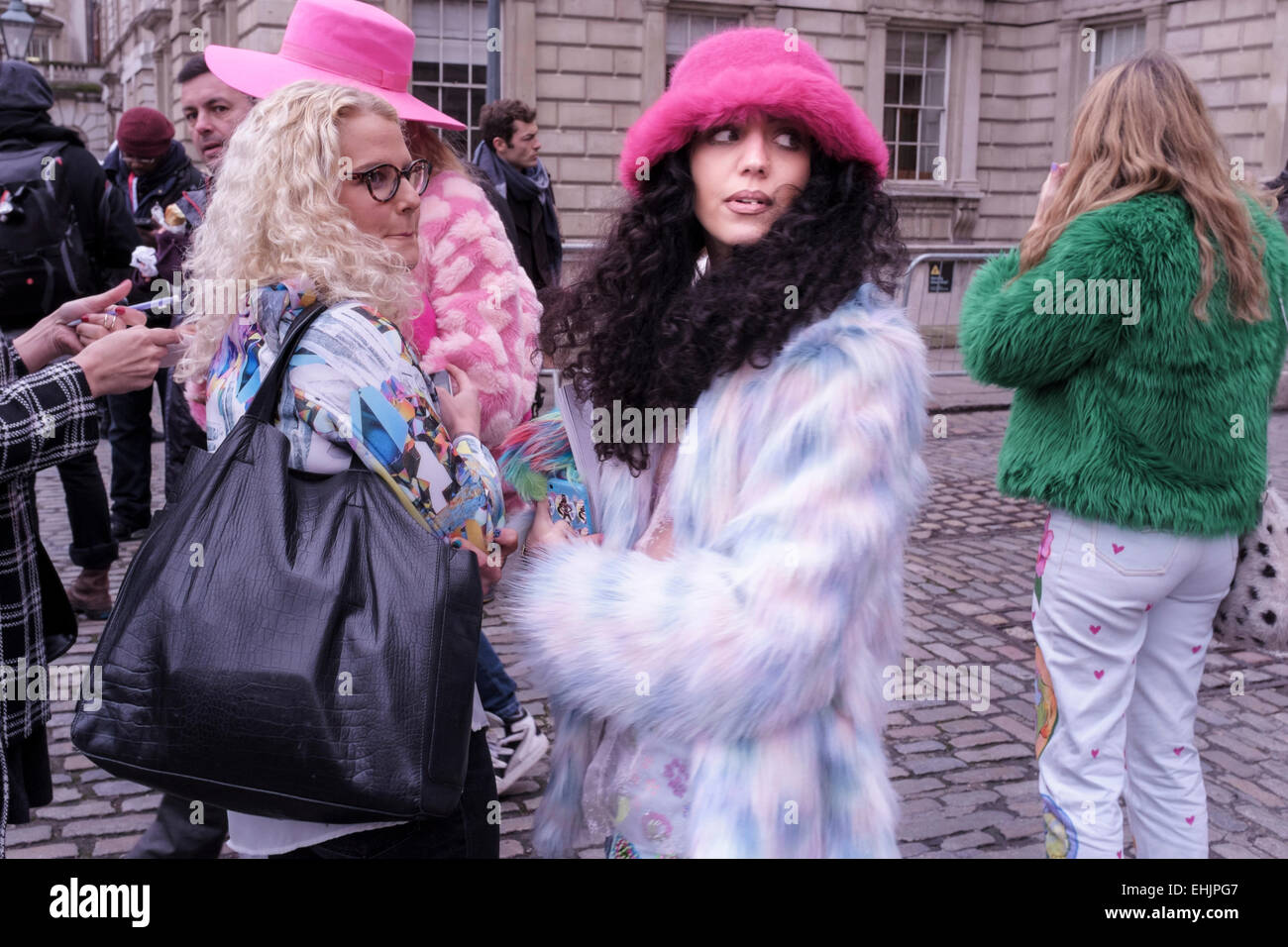 Modisch gekleidete junge Frauen besuchen London Fashion Week, Februar 2015. Stockfoto