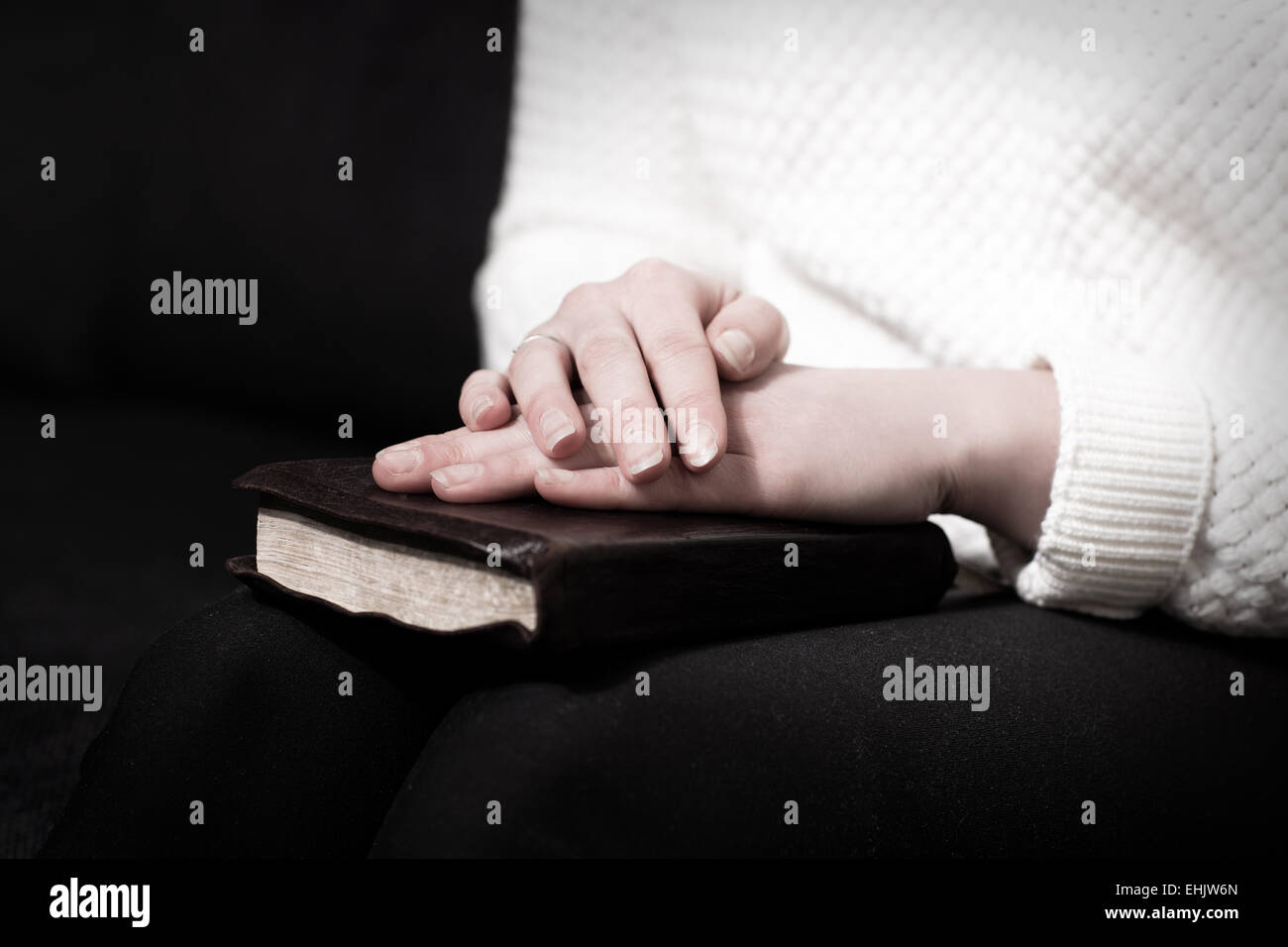 Frau, Hand in Hand über ihre Bibel und zu Gott zu beten. Stockfoto