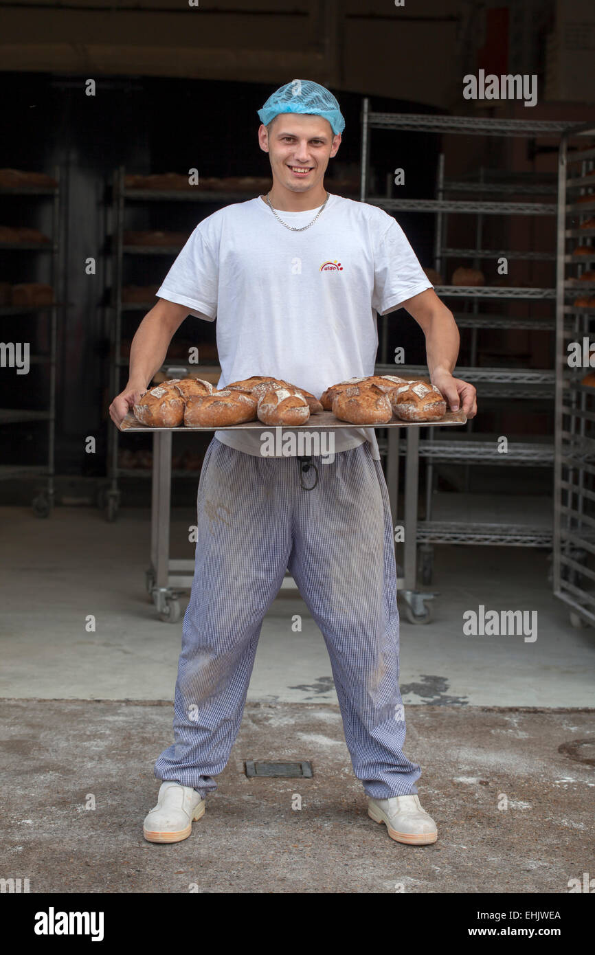 Baker, die holding ein Tablett mit frisch gebackenem Brot Stockfoto