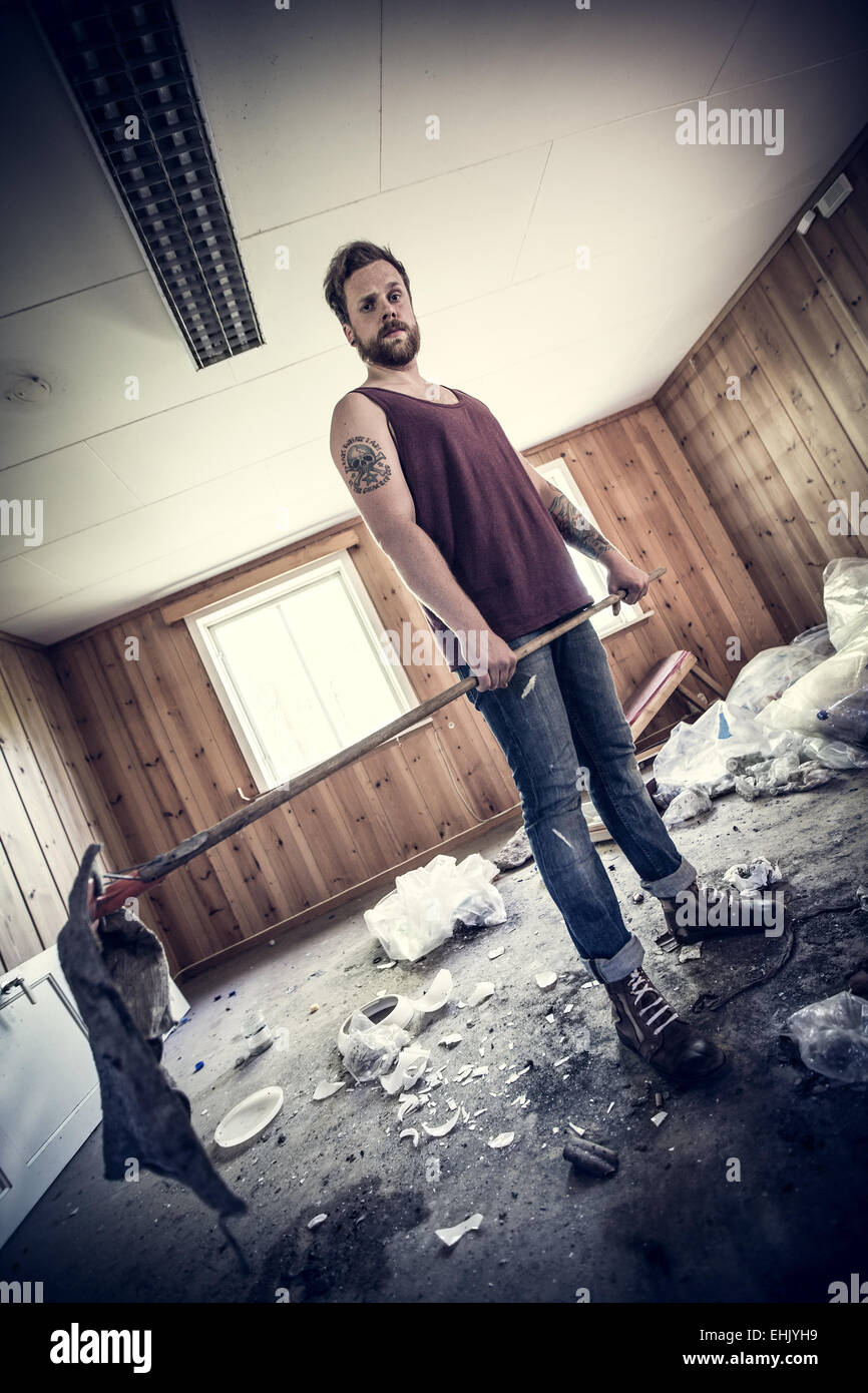 Ein junger Mann, Redneck / Punk Rocker Aufräumen nach Party, schmutzig und unordentlich Haus... Stockfoto