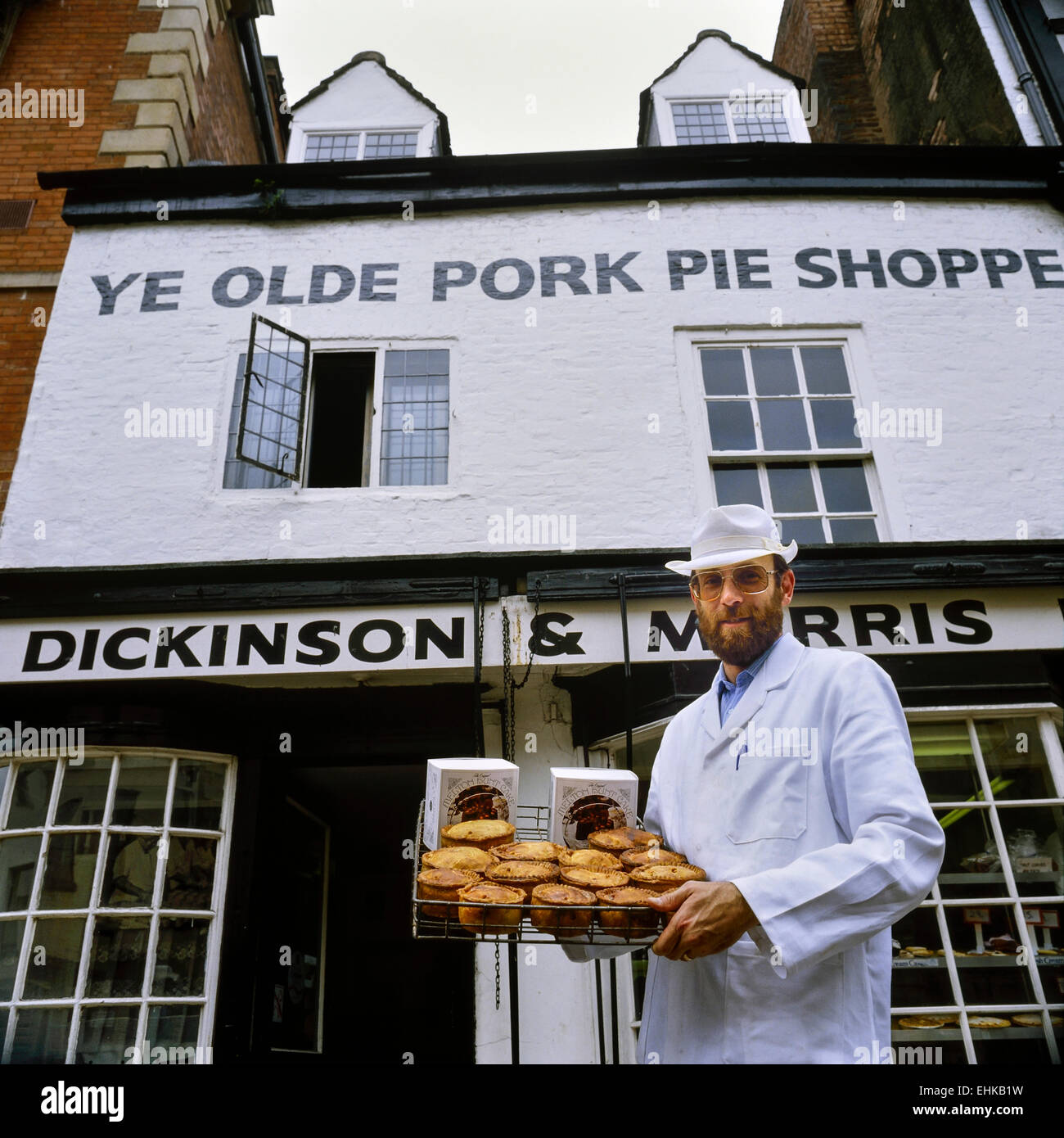 Ein Bäcker hält ein Tablett mit Melton Mowbray Schweinefleischpasteten & Melton Jagd Kuchen. Ye Olde Shoppe Pork Pie. Melton Mowbray. Leicestershire. Stockfoto