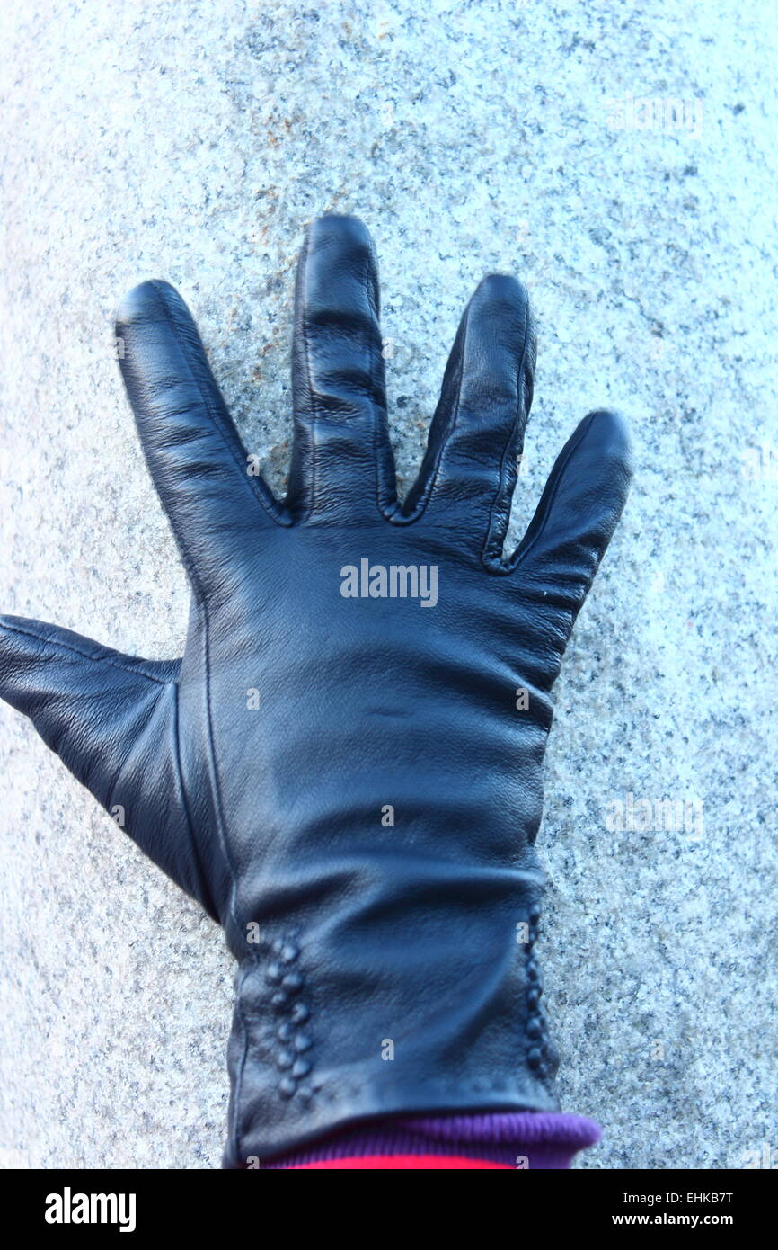 zeigt einen Teil einer behandschuhten Hand schwarz Stockfoto