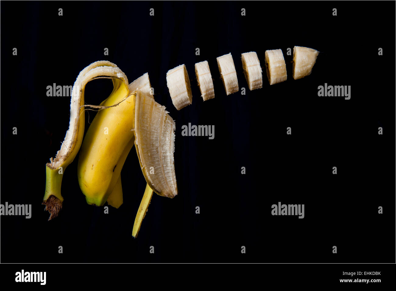Einem Trick Schuss eine Banane aufgeschnitten und in der Luft vor einem schwarzen Hintergrund schweben Stockfoto