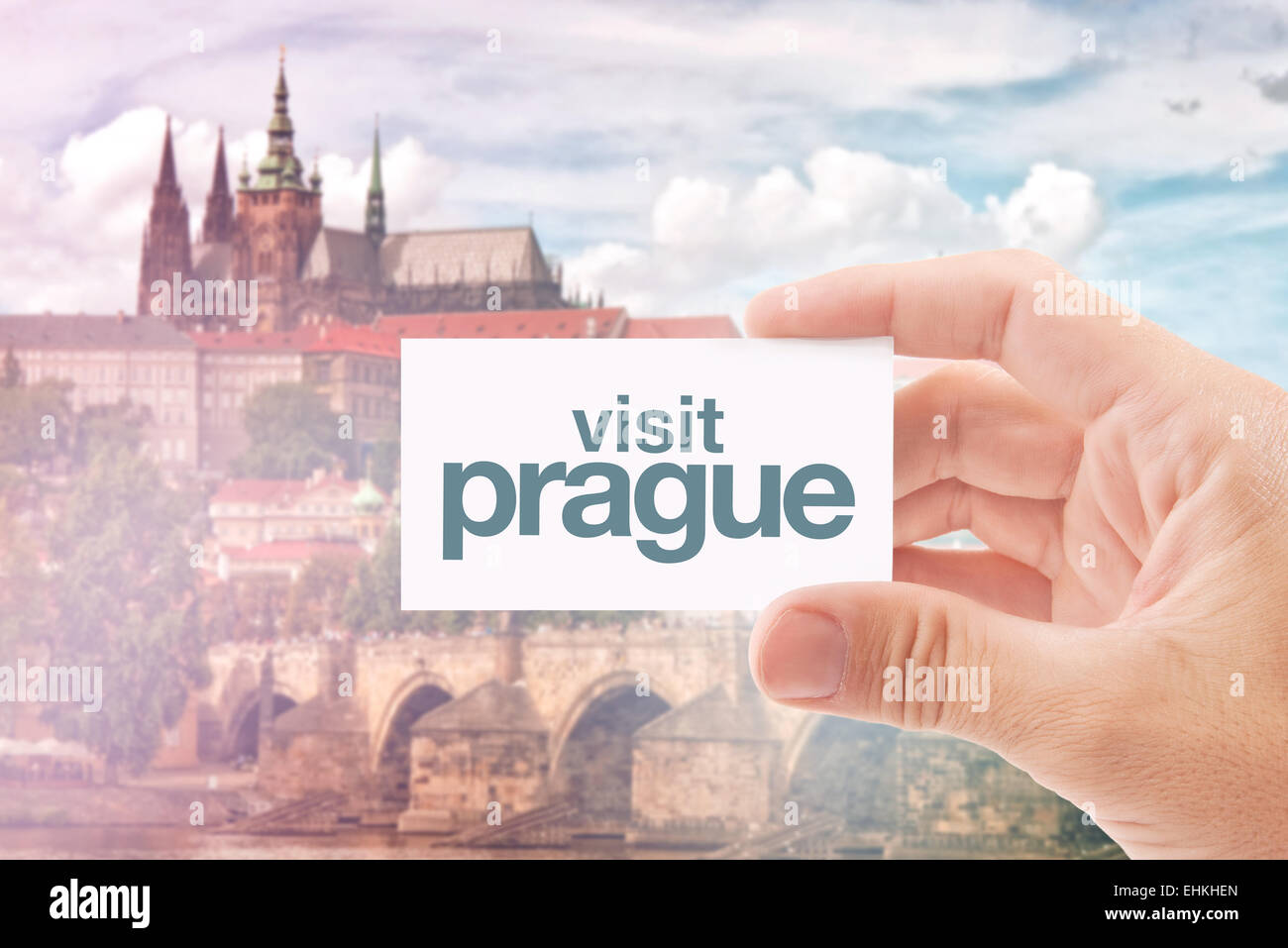 Touristischen Agenten halten Visitenkarte mit Besuch Prag Nachricht, berühmte Sehenswürdigkeiten der tschechischen Hauptstadt - Burg und Karlsbrücke Stockfoto